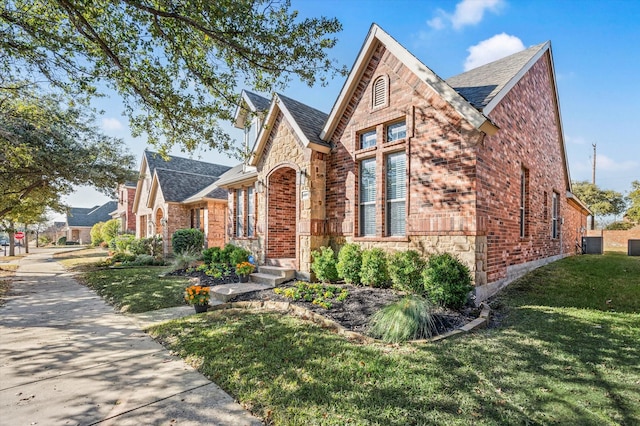 tudor house with a front yard and central AC unit