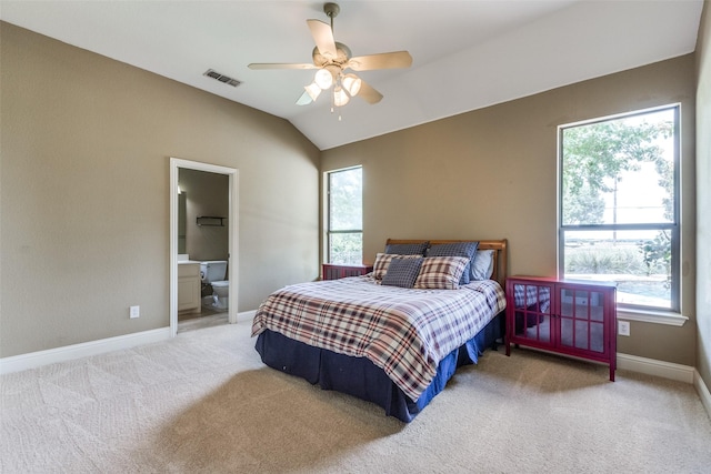 carpeted bedroom with ceiling fan, lofted ceiling, connected bathroom, and multiple windows