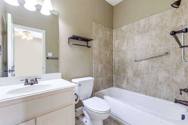 full bathroom with ceiling fan, toilet, vanity, and tiled shower / bath