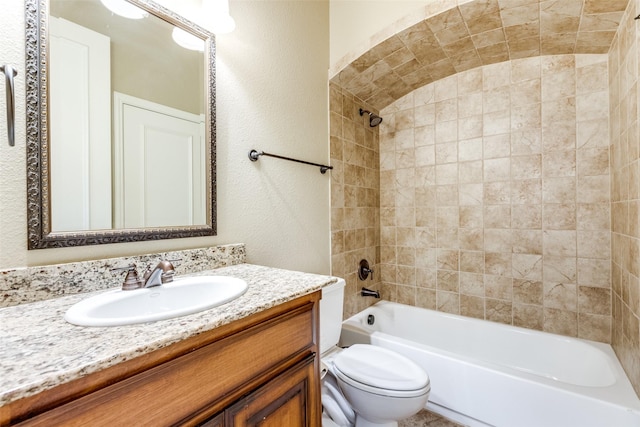 full bathroom featuring toilet, tiled shower / bath, and vanity