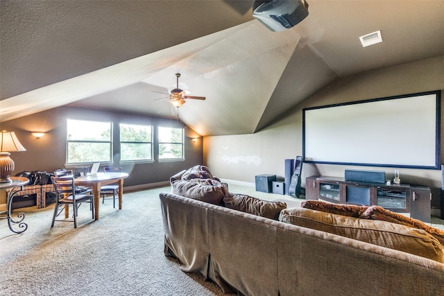 carpeted cinema room with ceiling fan and vaulted ceiling