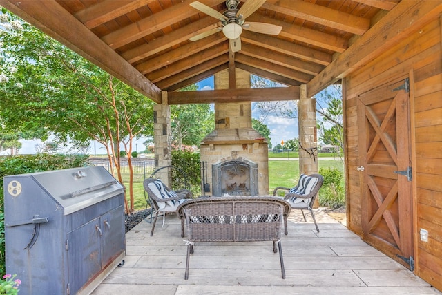 view of patio / terrace with ceiling fan, a gazebo, and an outdoor living space with a fireplace