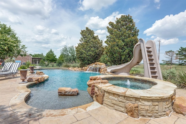 view of swimming pool featuring an in ground hot tub, a water slide, pool water feature, and a patio