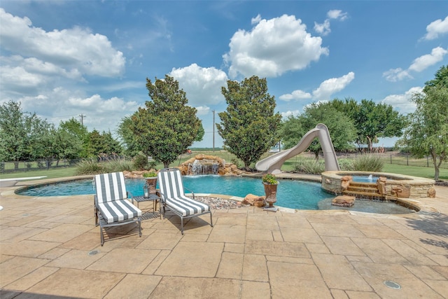 view of swimming pool featuring pool water feature, a patio area, a water slide, and an in ground hot tub