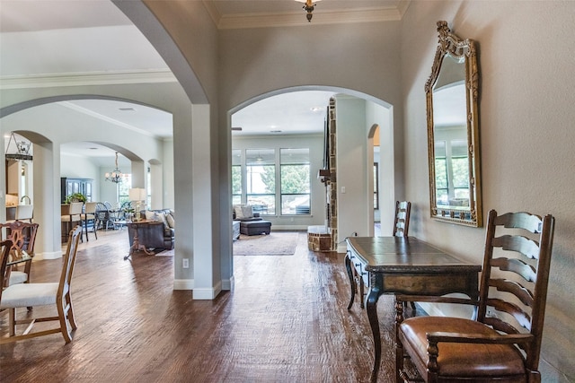 dining space featuring dark hardwood / wood-style floors, ornamental molding, and a chandelier