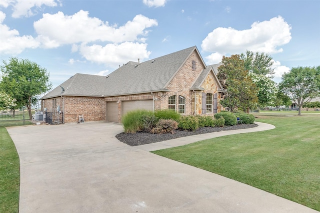 view of side of property featuring concrete driveway, a lawn, a shingled roof, a garage, and brick siding