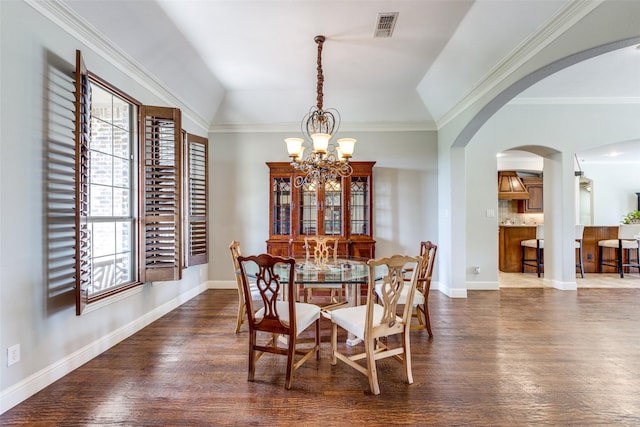 dining area with crown molding, a chandelier, lofted ceiling, and dark hardwood / wood-style floors