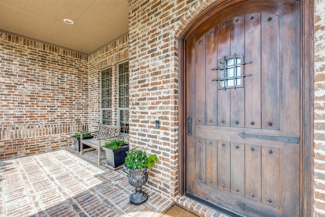 doorway to property with brick siding
