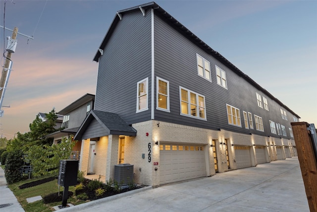 view of front of home featuring central air condition unit and a garage