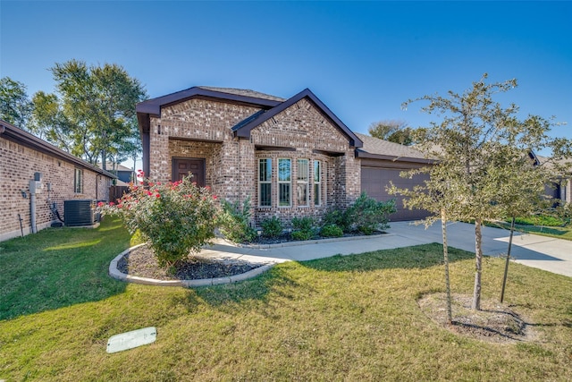 view of front facade with a front yard, central air condition unit, a garage, driveway, and brick siding
