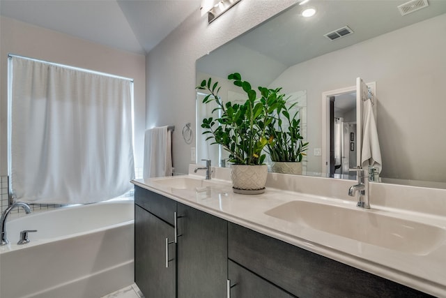 bathroom with a tub, vanity, and vaulted ceiling