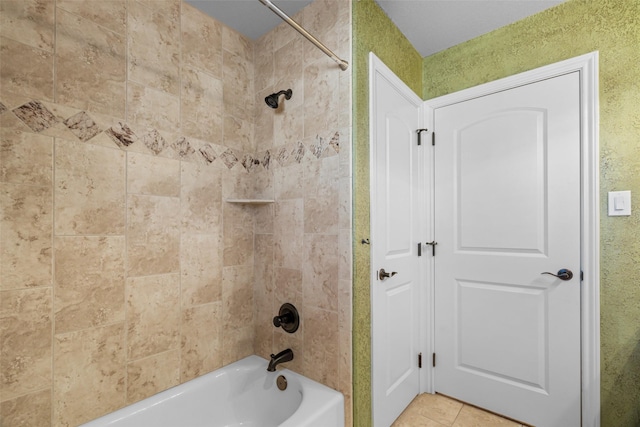 bathroom featuring tiled shower / bath combo and tile patterned flooring