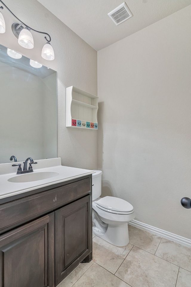 bathroom with toilet, tile patterned flooring, and vanity