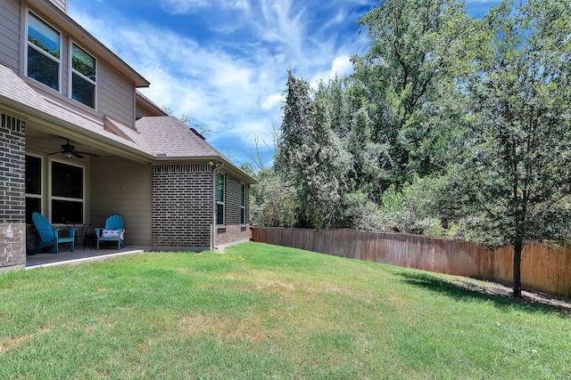 view of yard featuring ceiling fan and a patio