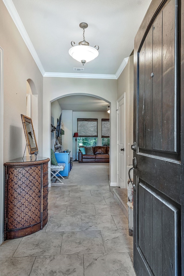 foyer entrance featuring ceiling fan and ornamental molding