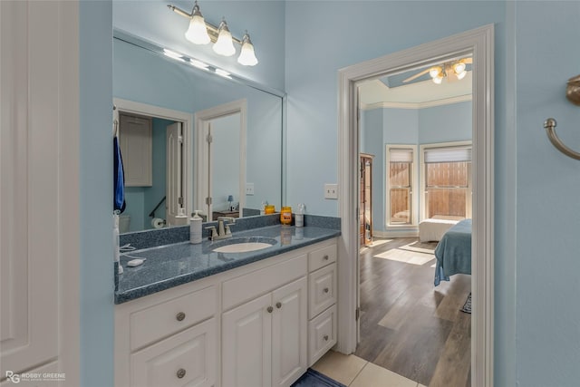 bathroom with ceiling fan, vanity, crown molding, and hardwood / wood-style flooring