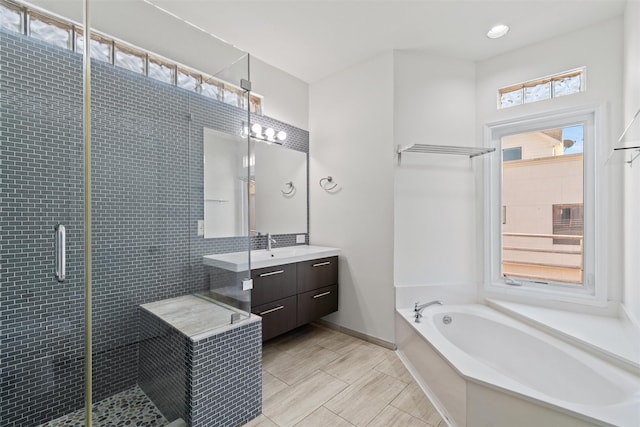 bathroom with vanity and shower with separate bathtub