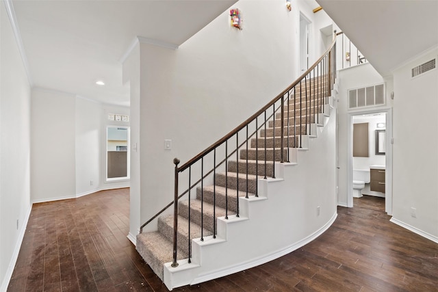 staircase featuring ornamental molding and hardwood / wood-style floors