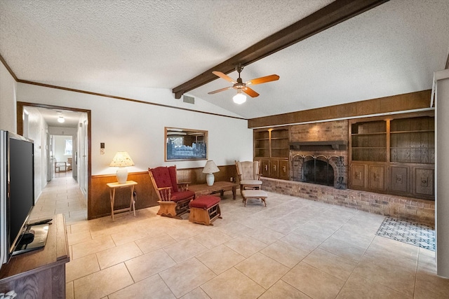 tiled living room featuring a textured ceiling, lofted ceiling with beams, a wainscoted wall, a fireplace, and built in features