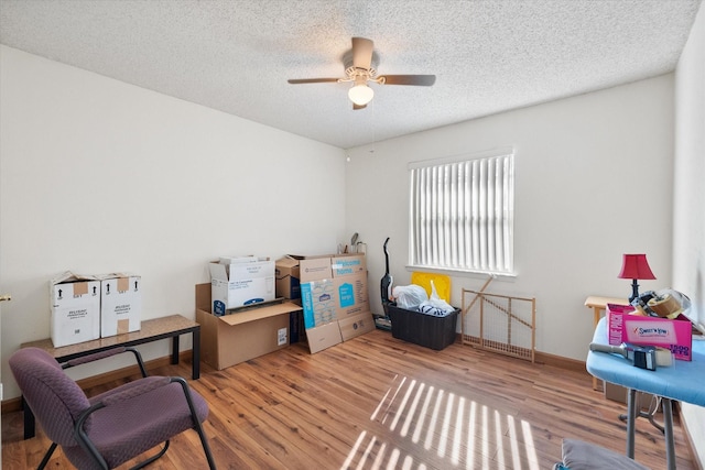 interior space featuring a textured ceiling, wood finished floors, and a ceiling fan