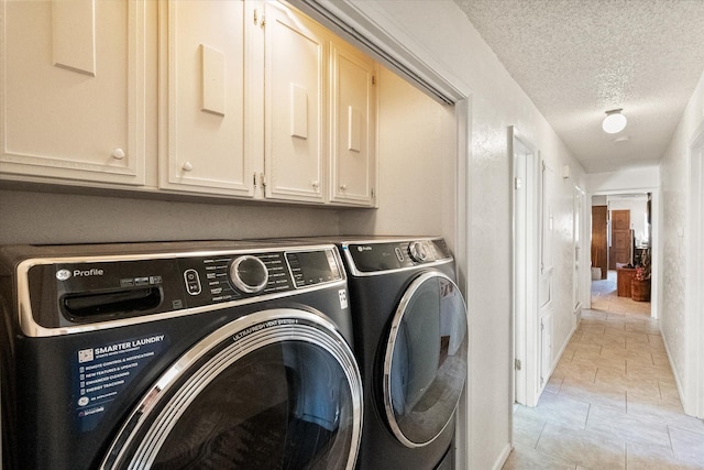 washroom featuring cabinet space, a textured ceiling, and independent washer and dryer