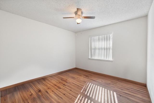 empty room featuring ceiling fan, a textured ceiling, and wood finished floors