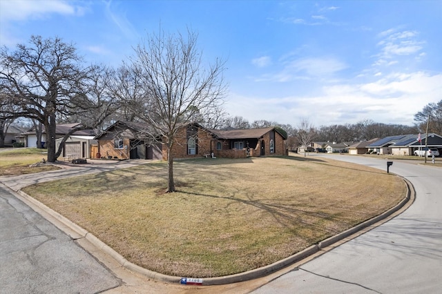 view of front of house featuring a residential view, brick siding, and a front lawn