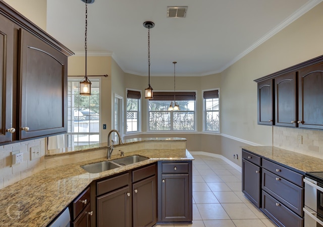 kitchen with pendant lighting, decorative backsplash, sink, crown molding, and dark brown cabinets