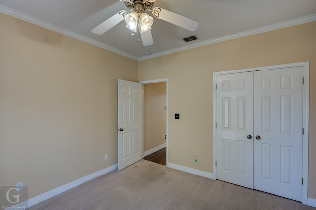 unfurnished bedroom featuring ceiling fan, ornamental molding, a closet, and light colored carpet