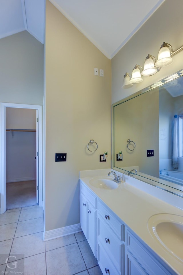 bathroom with ornamental molding, vanity, lofted ceiling, and tile patterned flooring