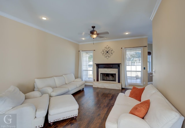 living room with a premium fireplace, crown molding, dark hardwood / wood-style floors, and ceiling fan