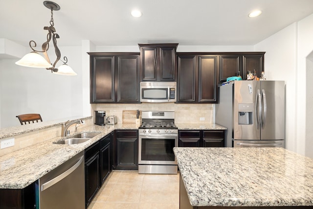 kitchen with backsplash, light stone countertops, recessed lighting, appliances with stainless steel finishes, and a sink