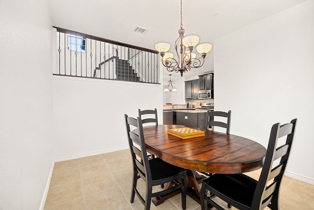 dining area featuring light tile patterned floors, visible vents, baseboards, and an inviting chandelier