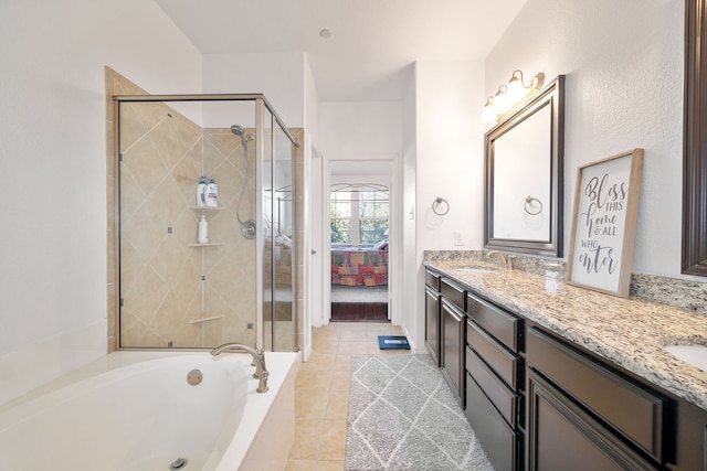 bathroom with tile patterned floors, a stall shower, and double vanity