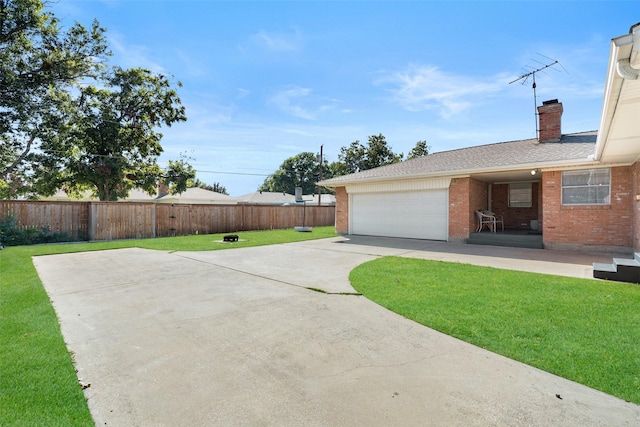 view of yard featuring a garage and a patio area