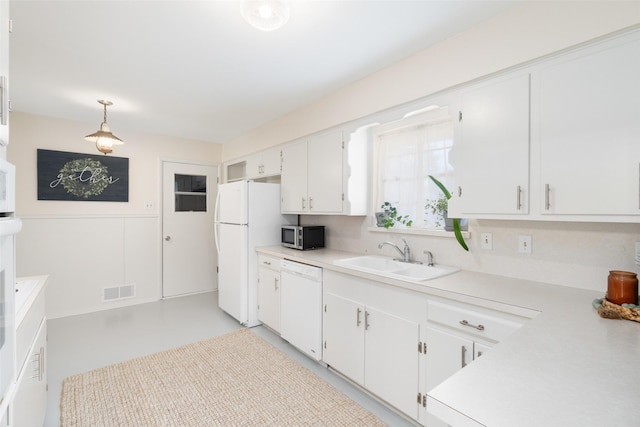 kitchen featuring white cabinetry, sink, white appliances, and hanging light fixtures