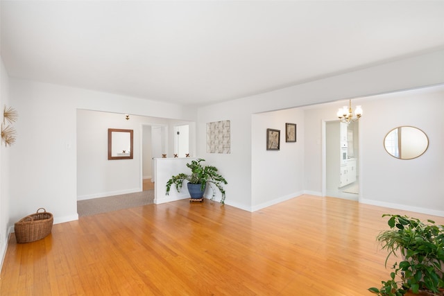 empty room with an inviting chandelier and hardwood / wood-style flooring