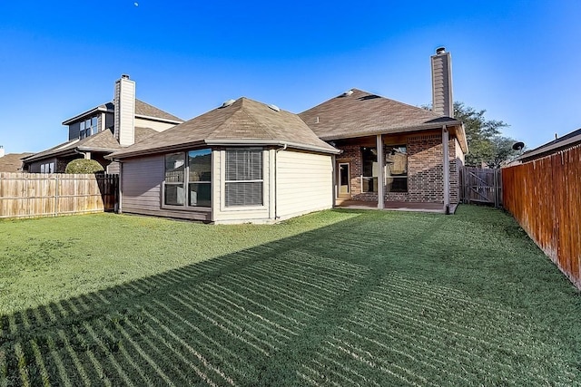 back of house with a patio area and a yard