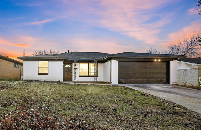 view of front of home with a yard and a garage