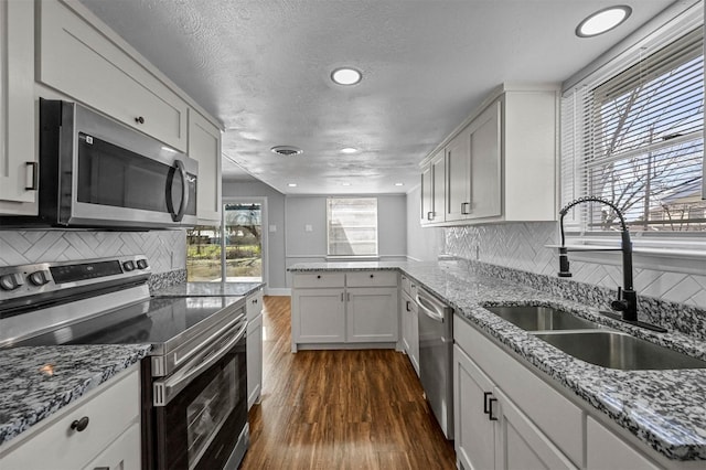 kitchen with stainless steel appliances, backsplash, dark wood-type flooring, a textured ceiling, and sink