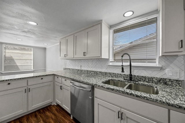 kitchen featuring white cabinetry, dishwasher, backsplash, and sink