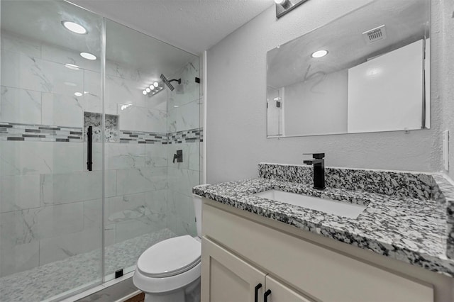 bathroom featuring a textured ceiling, toilet, an enclosed shower, and vanity