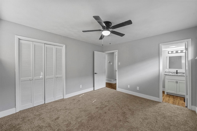 unfurnished bedroom featuring ceiling fan, carpet flooring, a closet, and ensuite bath