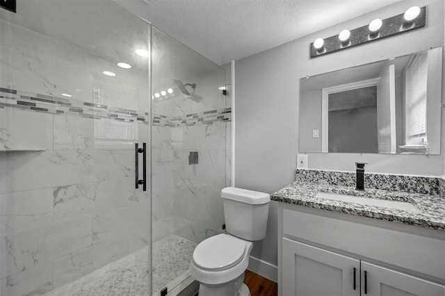 bathroom featuring a textured ceiling, an enclosed shower, wood-type flooring, vanity, and toilet