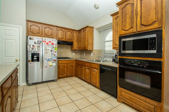 kitchen featuring backsplash, black appliances, sink, light tile patterned floors, and a chandelier