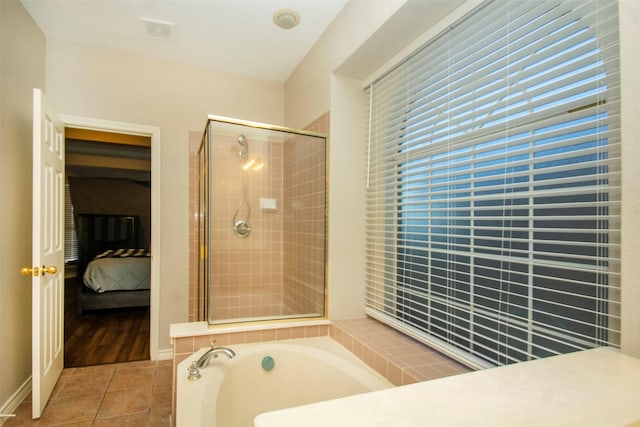 bathroom with separate shower and tub and tile patterned floors