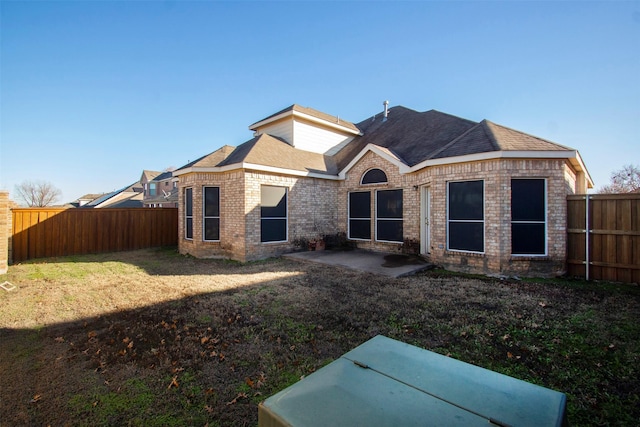 rear view of house with a lawn and a patio