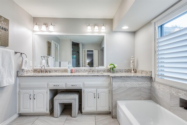 bathroom featuring vanity and a bath