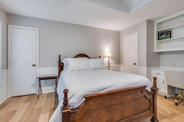 bedroom featuring a textured ceiling and light hardwood / wood-style flooring