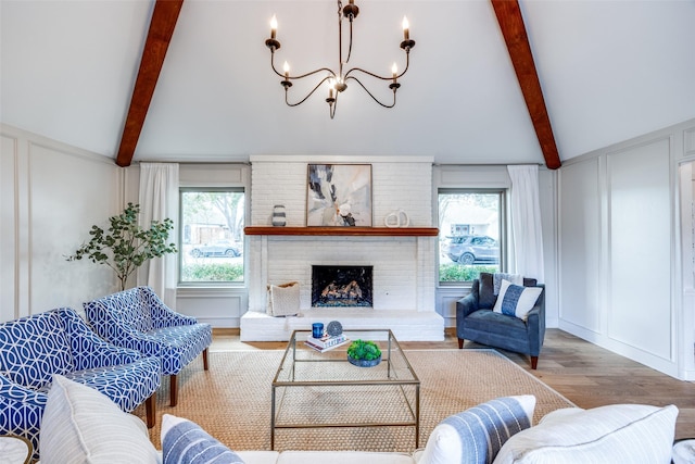 living room with an inviting chandelier, vaulted ceiling with beams, a fireplace, and wood-type flooring